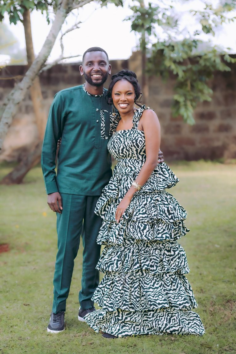 Ivyonne and Dennis smiling together in matching green outfits